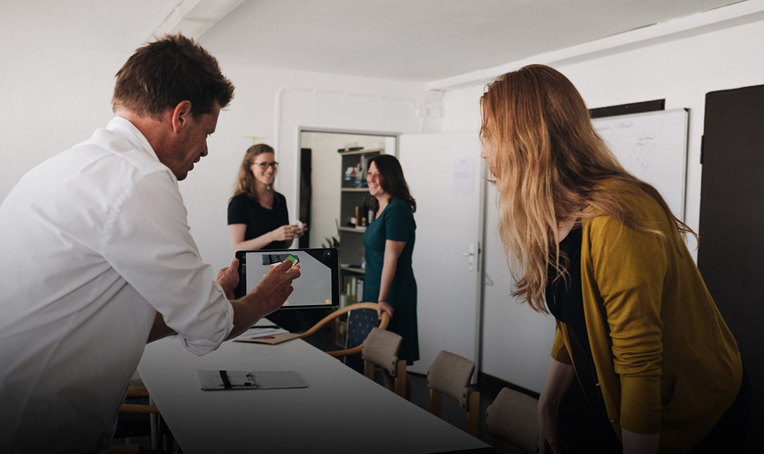 Vier Menschen arbeiten und sprechen in einem Büro.